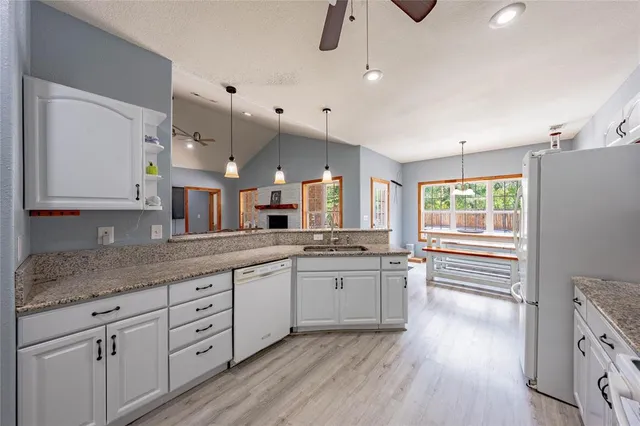 a large kitchen with granite countertop a large window a sink and stainless steel appliances