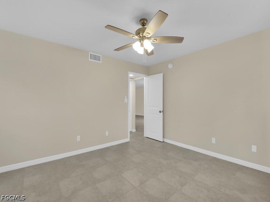 16560 Partridge Place Road, Unit 101 Fort Myers, FL 33908 - Photo 17 of 27 an empty room with a chandelier fan and windows