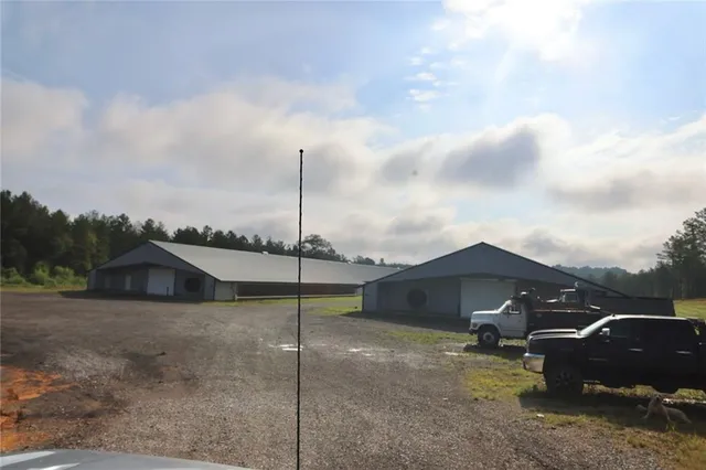 a view of a house with a backyard and a forest