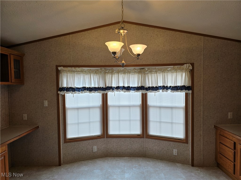 450 Beeman Road Washington, WV 26181 - Photo 3 of 24 Unfurnished dining area featuring a textured ceiling, a notable chandelier, lofted ceiling, and crown molding