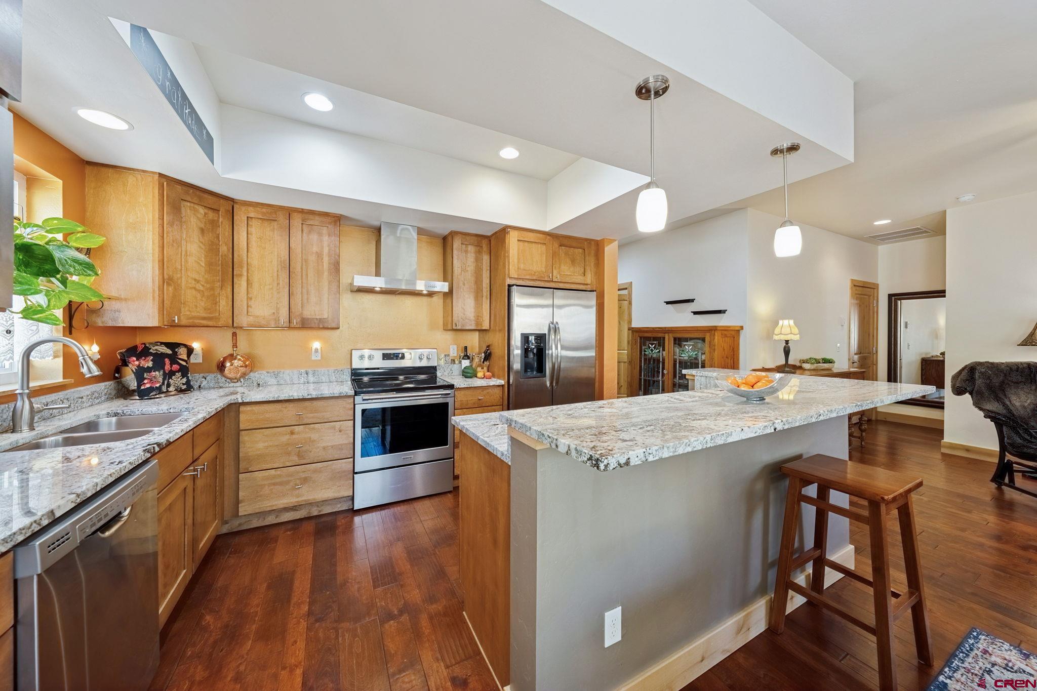 67 Mountain Stream Court Durango, CO 81301 - Photo 13 of 35 a kitchen with stainless steel appliances granite countertop wooden cabinets sink and stove