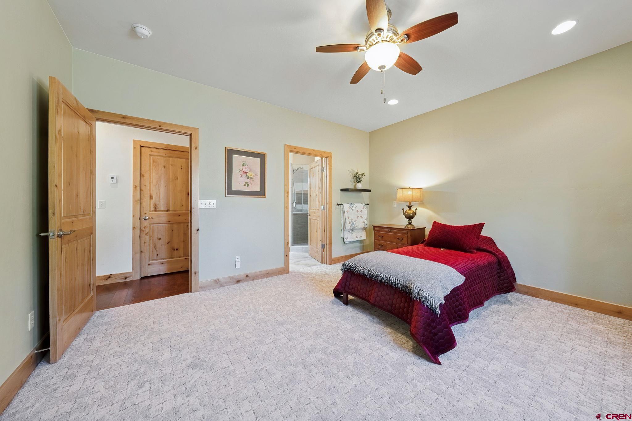 67 Mountain Stream Court Durango, CO 81301 - Photo 23 of 35 a spacious bedroom with a bed and a chandelier