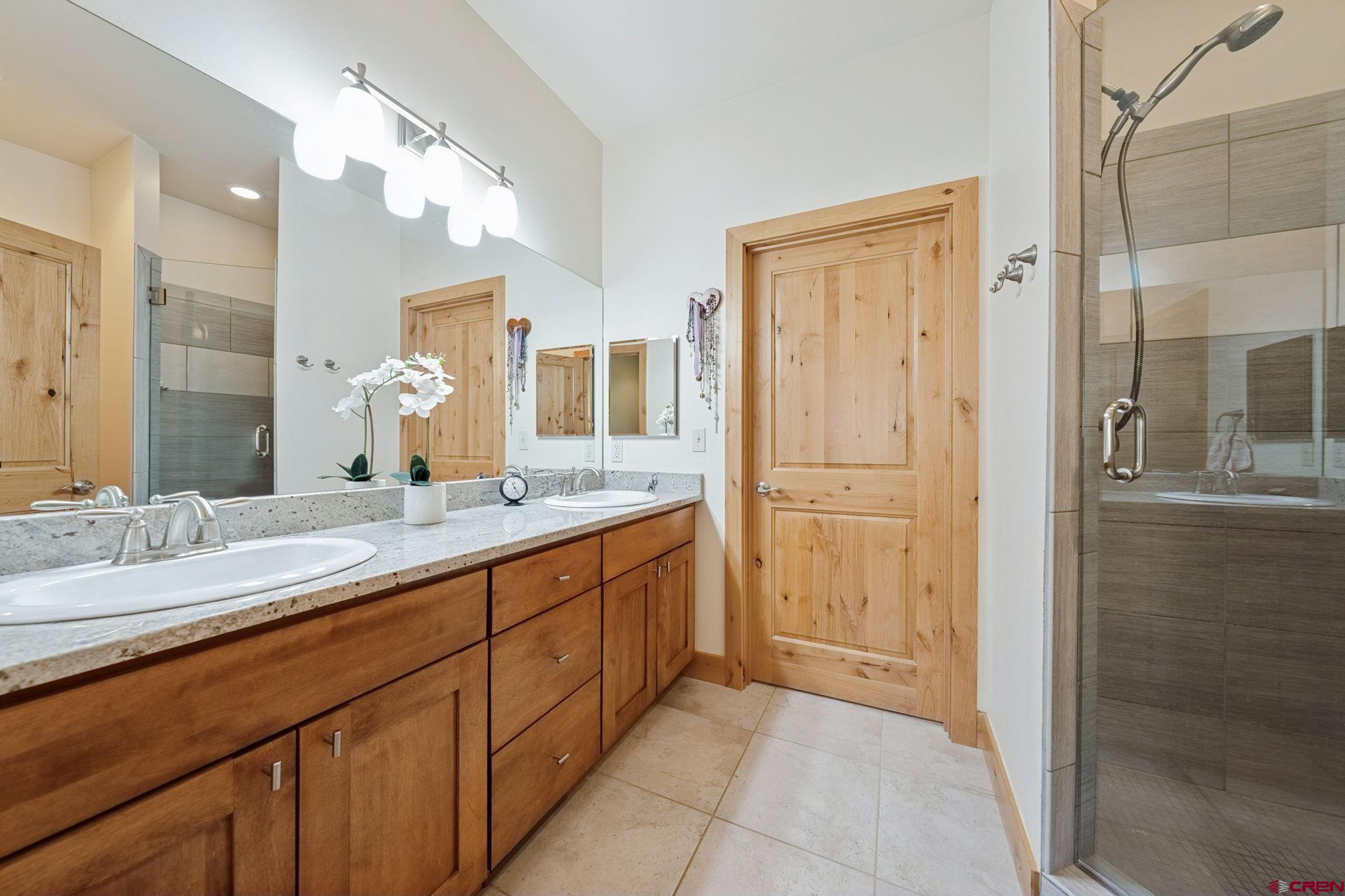 67 Mountain Stream Court Durango, CO 81301 - Photo 24 of 35 a bathroom with a granite countertop sink mirror and double