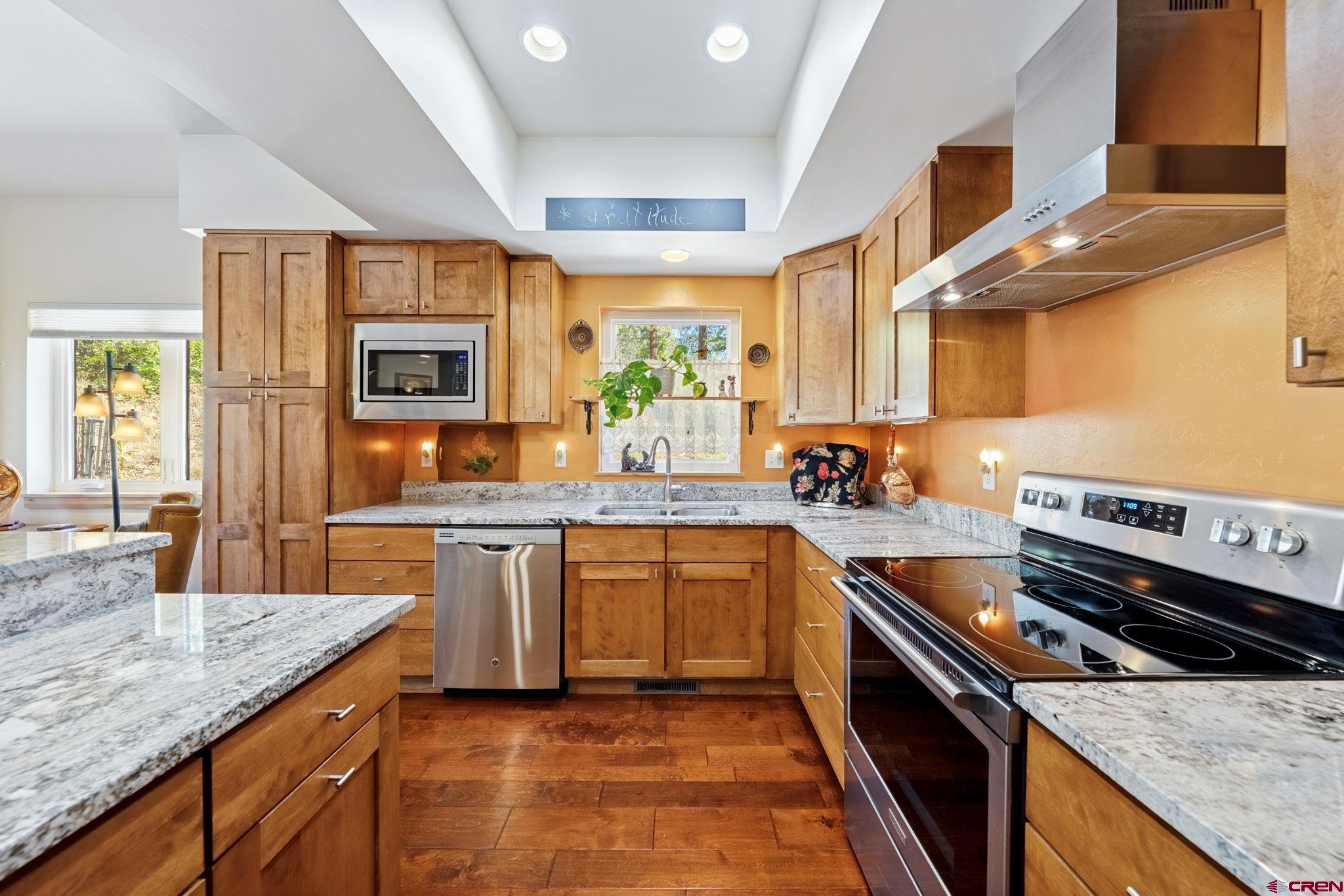 67 Mountain Stream Court Durango, CO 81301 - Photo 6 of 35 a kitchen with stainless steel appliances granite countertop a stove a sink and a microwave