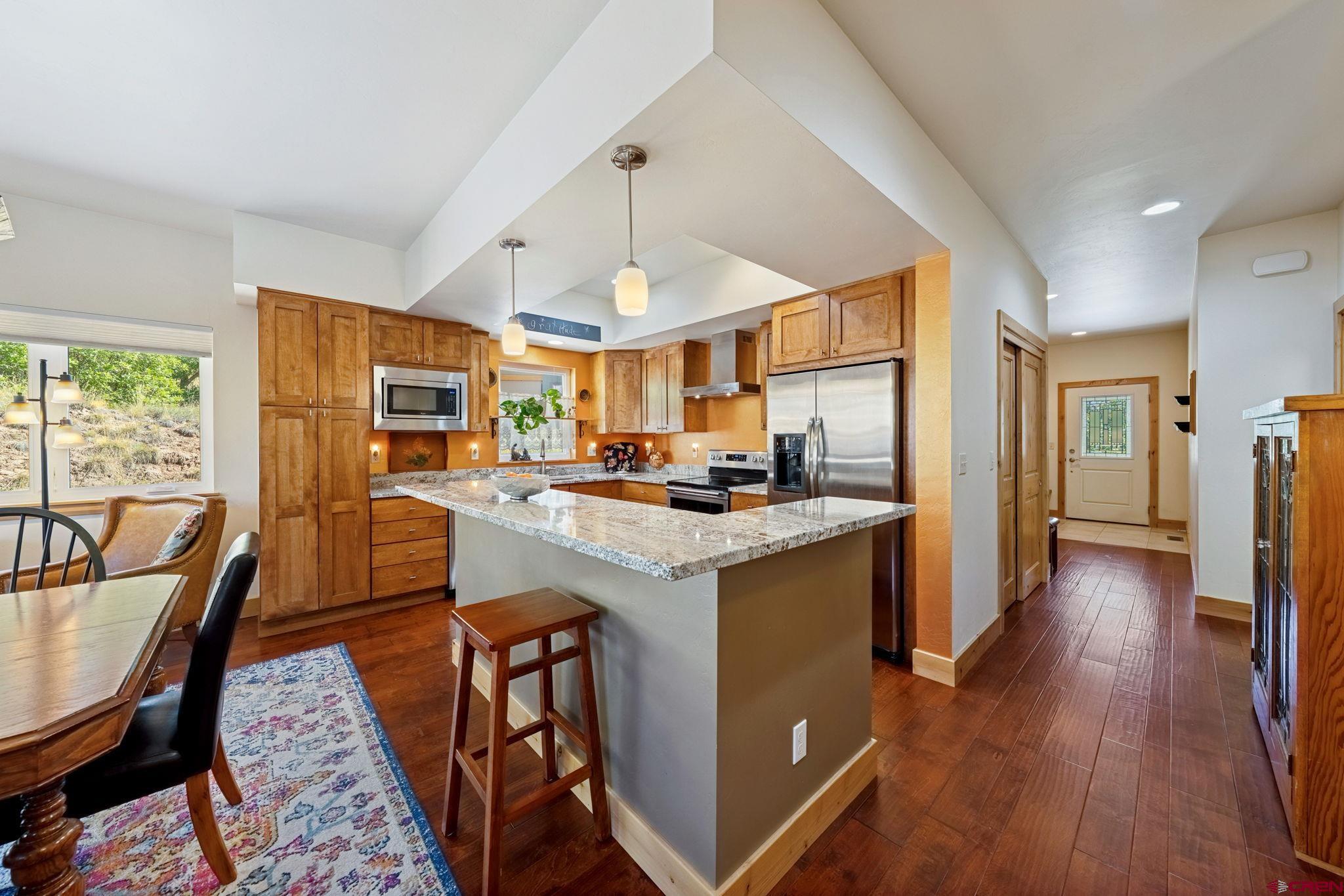 67 Mountain Stream Court Durango, CO 81301 - Photo 7 of 35 a kitchen with stainless steel appliances granite countertop sink stove top oven and cabinets