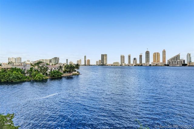a view of a swimming pool with a yard and palm trees