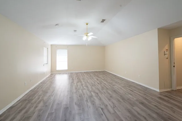 wooden floor in an empty room with a window