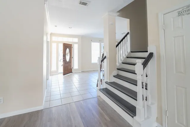 a view of a hallway with wooden floor and staircase