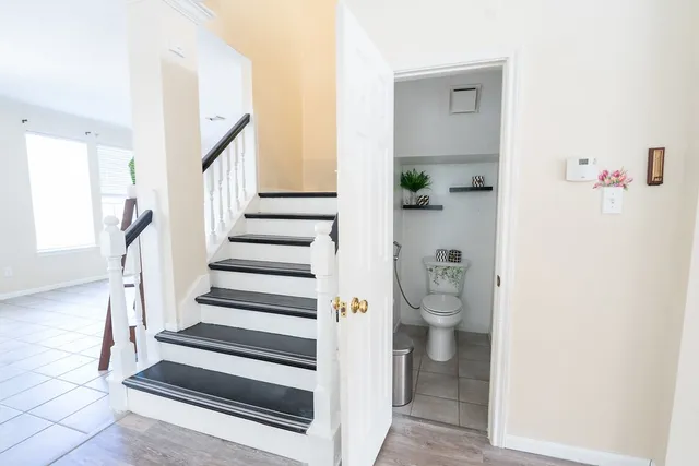 a view of a hallway with wooden floor and staircase