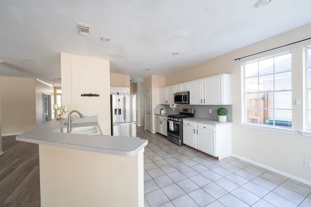 a kitchen with stainless steel appliances kitchen island granite countertop a sink and a stove top oven