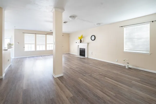 an empty room with wooden floor and windows