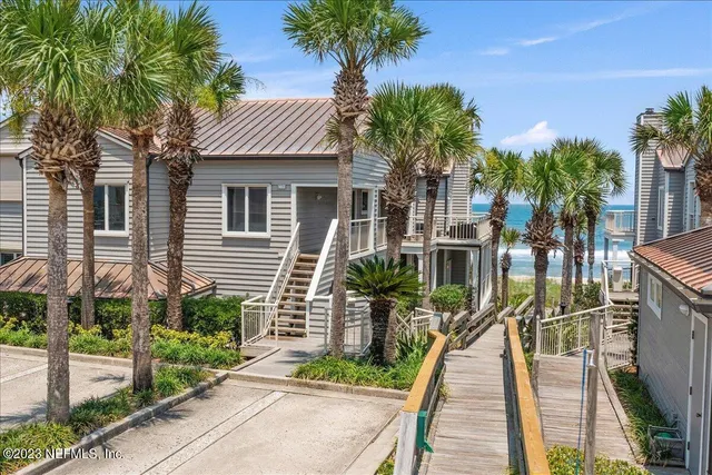 a front view of a house with a yard and potted plants