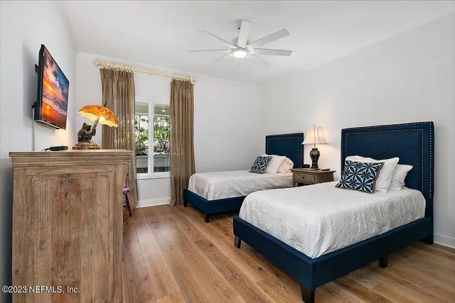 a bedroom with two beds and a flat screen tv