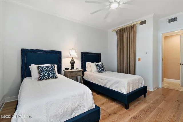 a bedroom with two beds and a chandelier