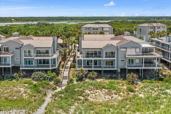 a front view of a house with a garden and lake view