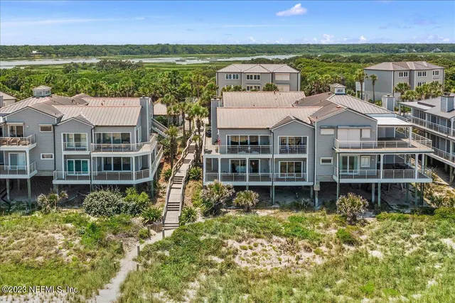 a front view of a house with a garden and lake view
