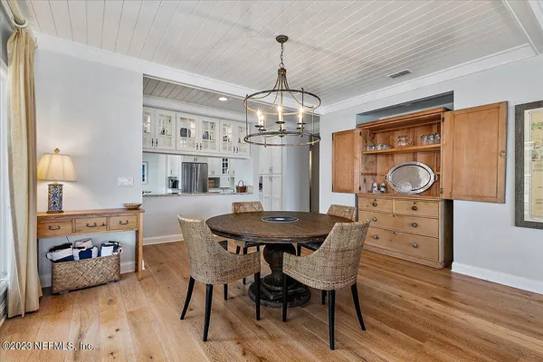 a dining room with furniture a chandelier and wooden floor
