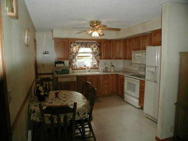 9478 North Excelsior Road Lena, IL 61048 - Photo 4 of 9 a kitchen with a table chairs a sink dishwasher window and cabinets