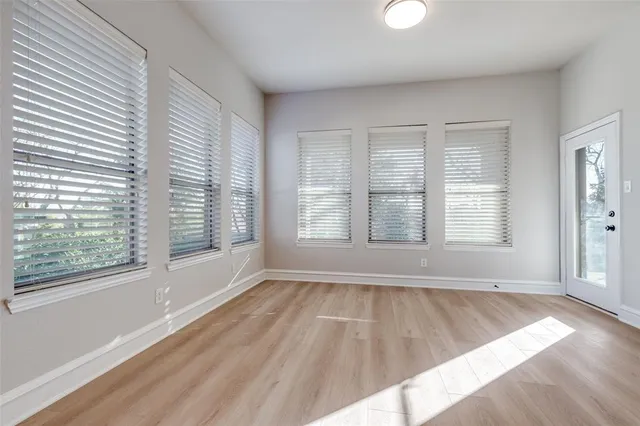 an empty room with windows and a fireplace