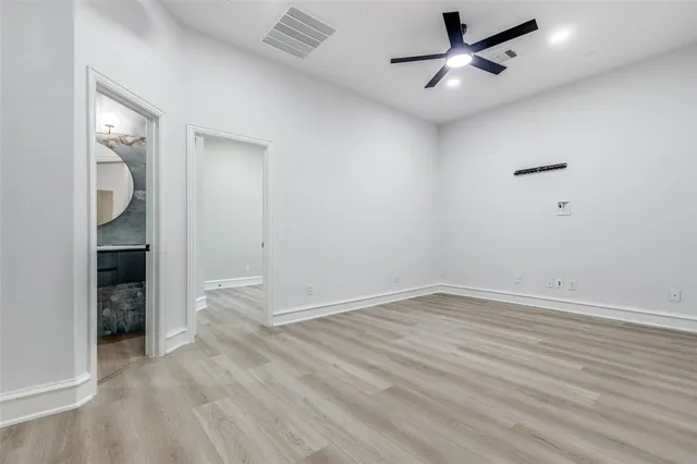 an empty room with a window and a fan