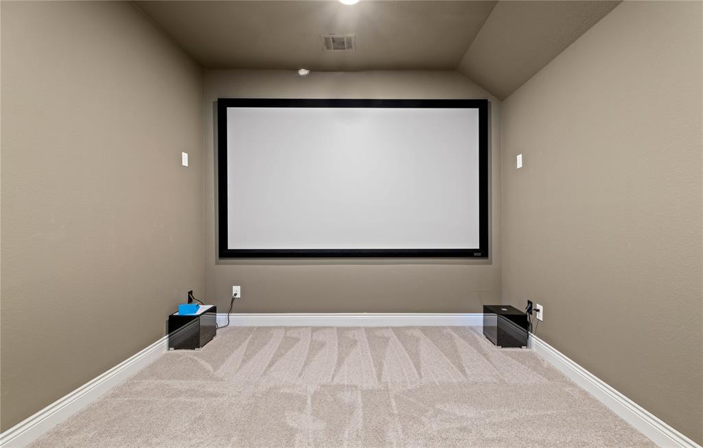 16541 Sweetgum Road Frisco, TX 75033 - Photo 20 of 26 Dedicated media room featuring a large projection screen and light-toned, textured carpet