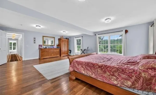a spacious bedroom with a large bed and wooden floor