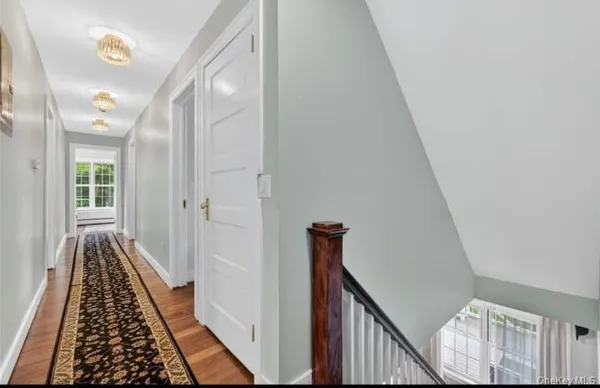a view of a hallway with wooden floor and staircase