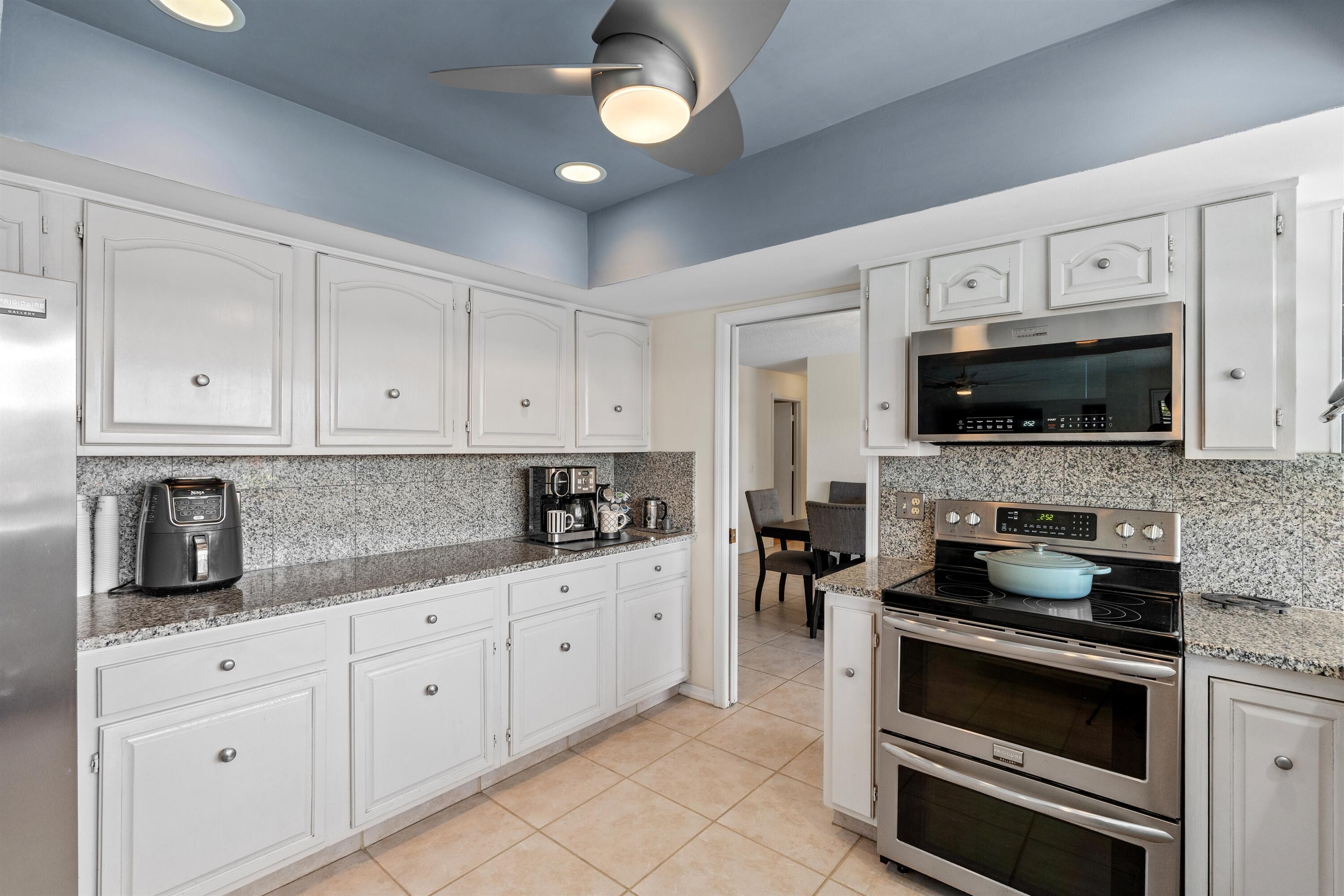 1223 Pepperridge Terrace Boca Raton, FL 33486 - Photo 11 of 34 a kitchen with granite countertop white cabinets stainless steel appliances and a sink