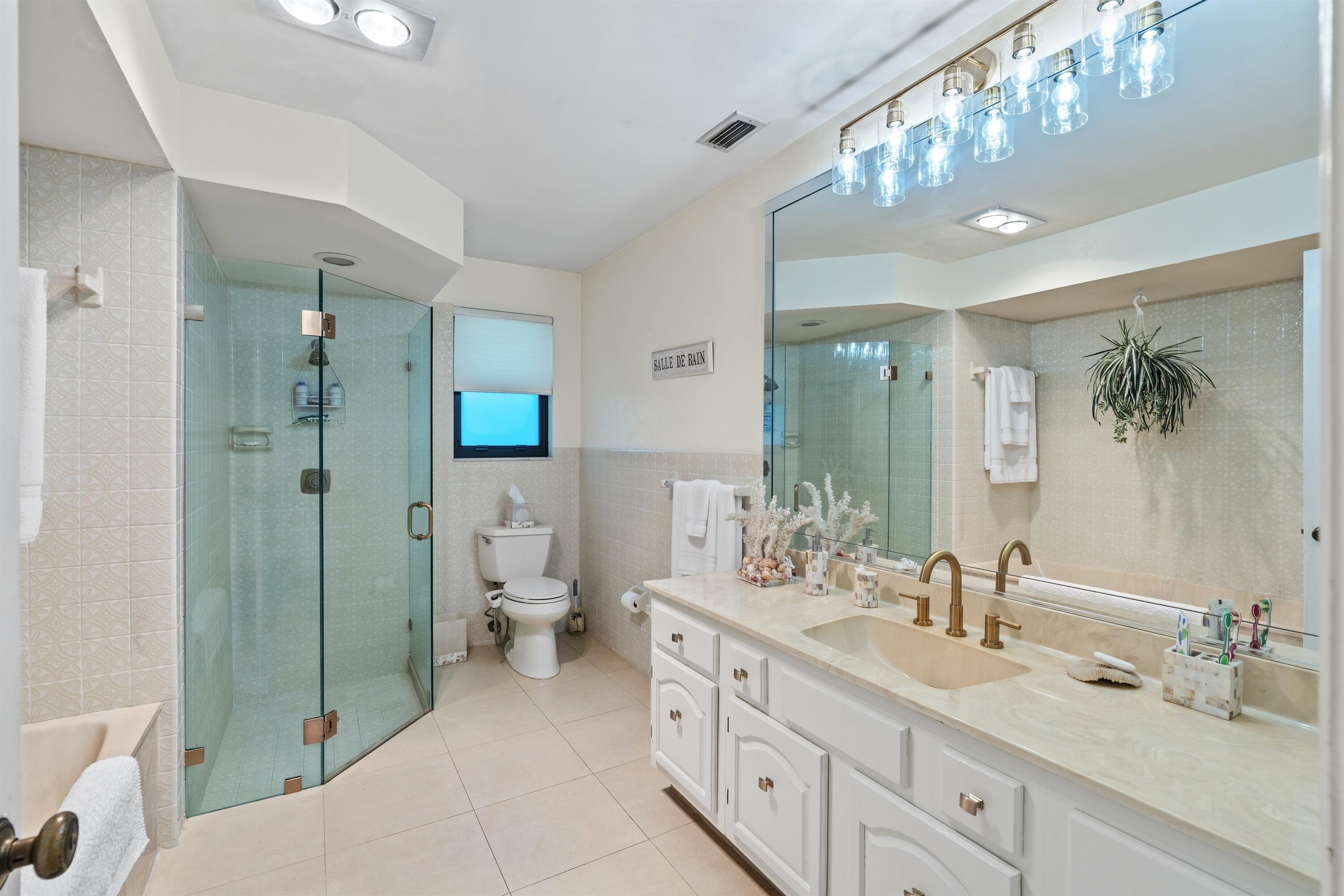 1223 Pepperridge Terrace Boca Raton, FL 33486 - Photo 18 of 34 a spacious bathroom with a double vanity sink toilet mirror and shower