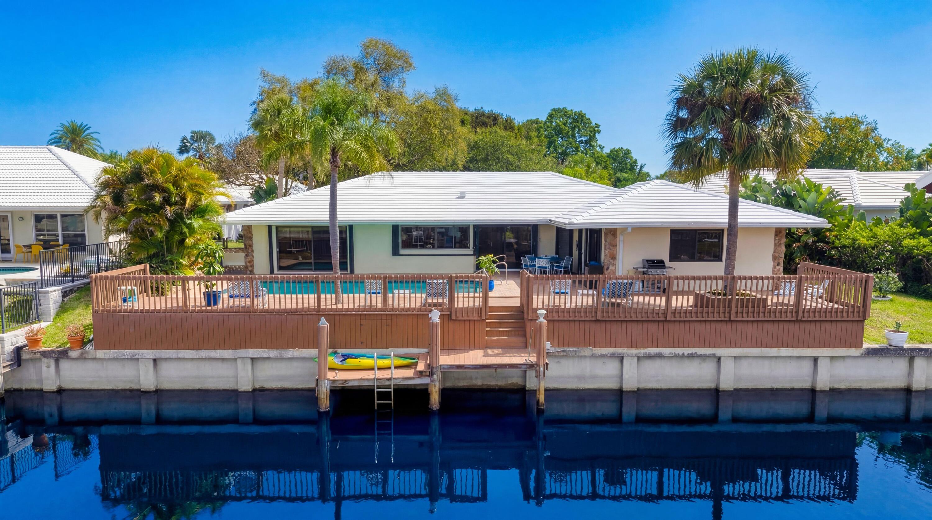 1223 Pepperridge Terrace Boca Raton, FL 33486 - Photo 33 of 34 a view of a patio with couches table and chairs under an umbrella with a barbeque