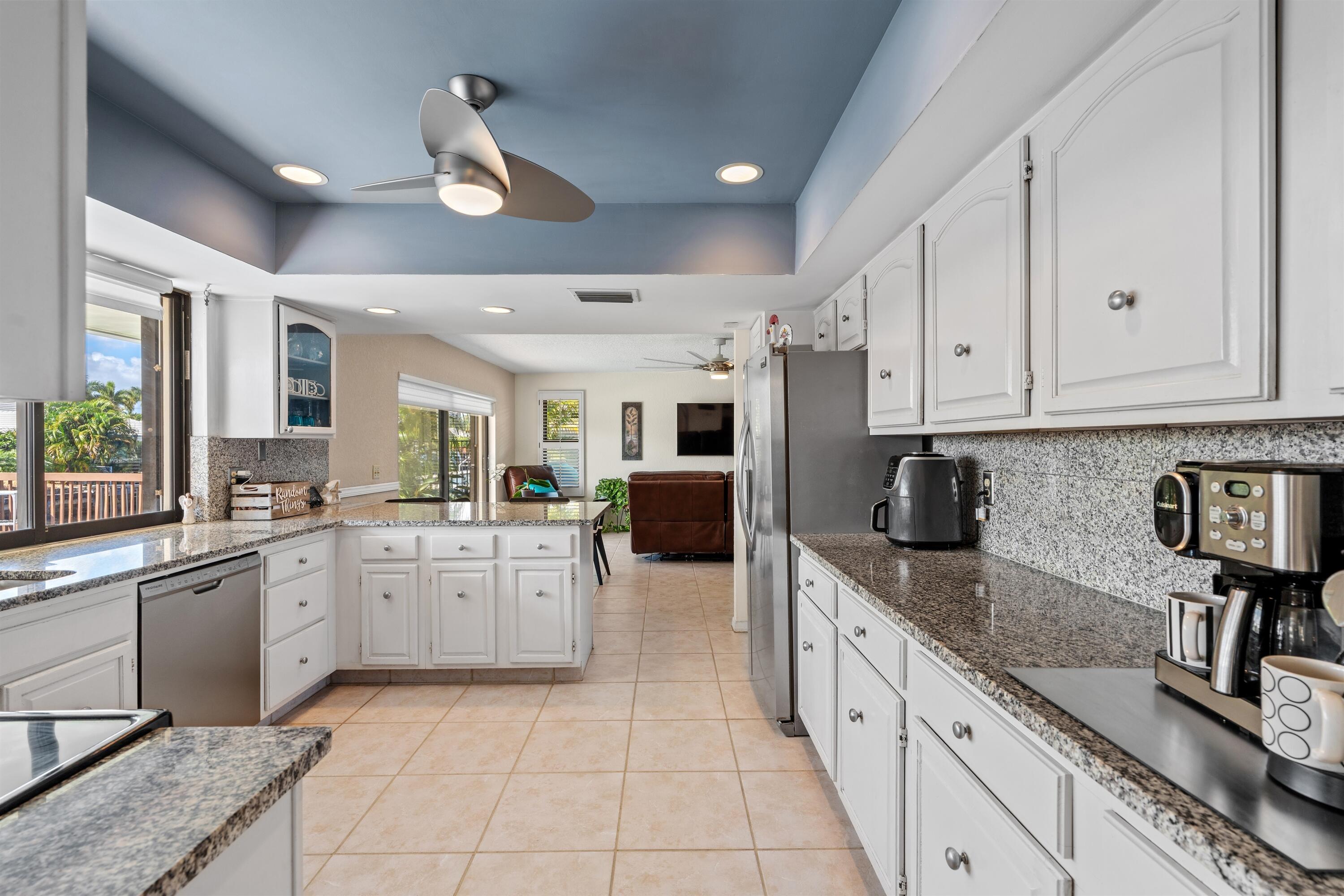 1223 Pepperridge Terrace Boca Raton, FL 33486 - Photo 9 of 34 a large kitchen with stainless steel appliances granite countertop a sink and dishwasher a stove top oven with white cabinets