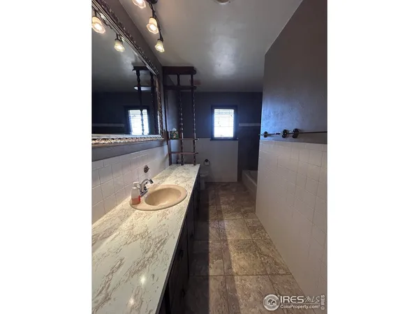 a bathroom with a granite countertop sink and a mirror