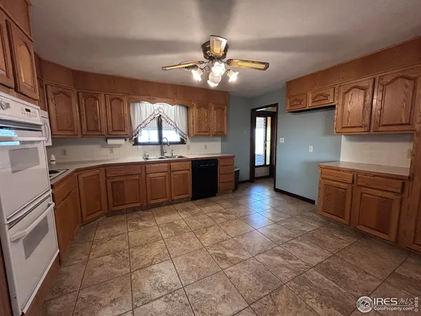 a kitchen with granite countertop a sink stainless steel appliances and cabinets