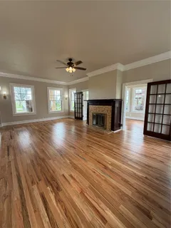 an empty room with wooden floor and fireplace