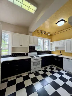 a kitchen with a checkered floor and white cabinets