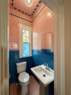 a bathroom with a toilet sink and mirror
