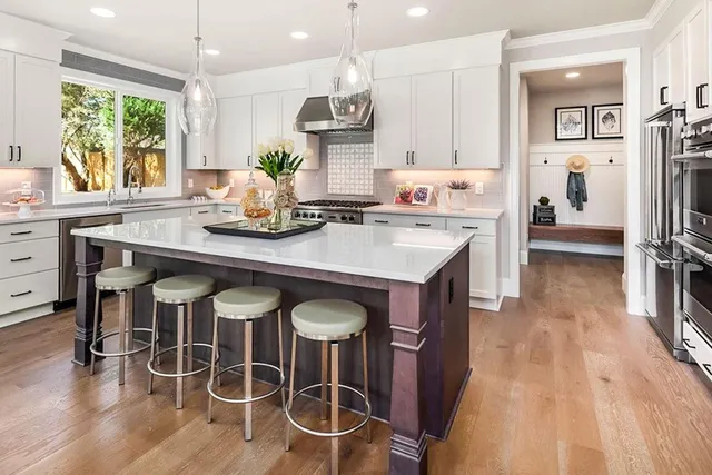a kitchen with stainless steel appliances a table chairs refrigerator and sink