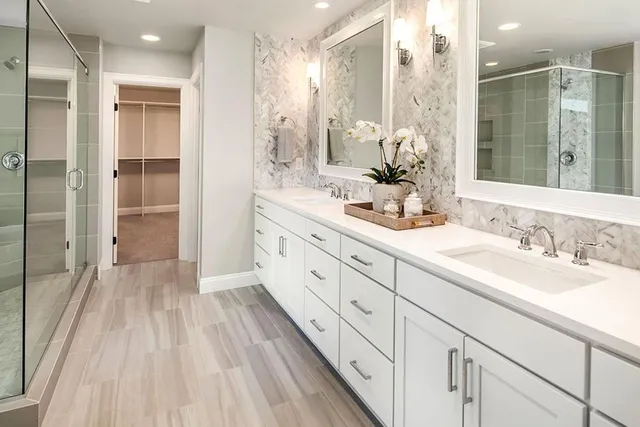 a spacious bathroom with a double vanity sink mirror and shower