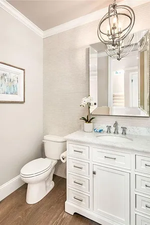 a bathroom with a granite countertop toilet sink and mirror