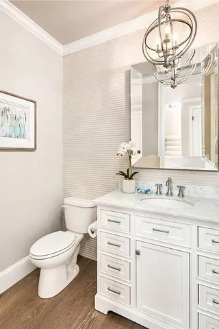 a bathroom with a granite countertop toilet sink and mirror