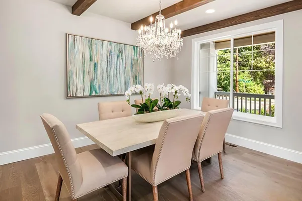 a view of a dining room with furniture a chandelier and wooden floor