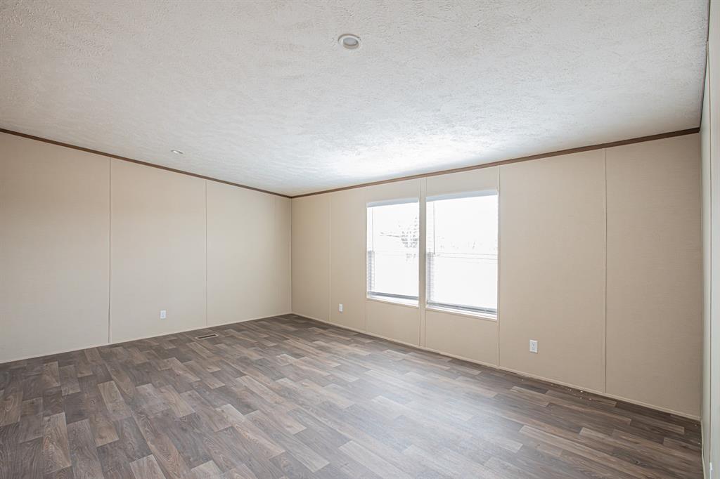 150 Leech Road Poolville, TX 76487 - Photo 14 of 34 an empty room with wooden floor and windows