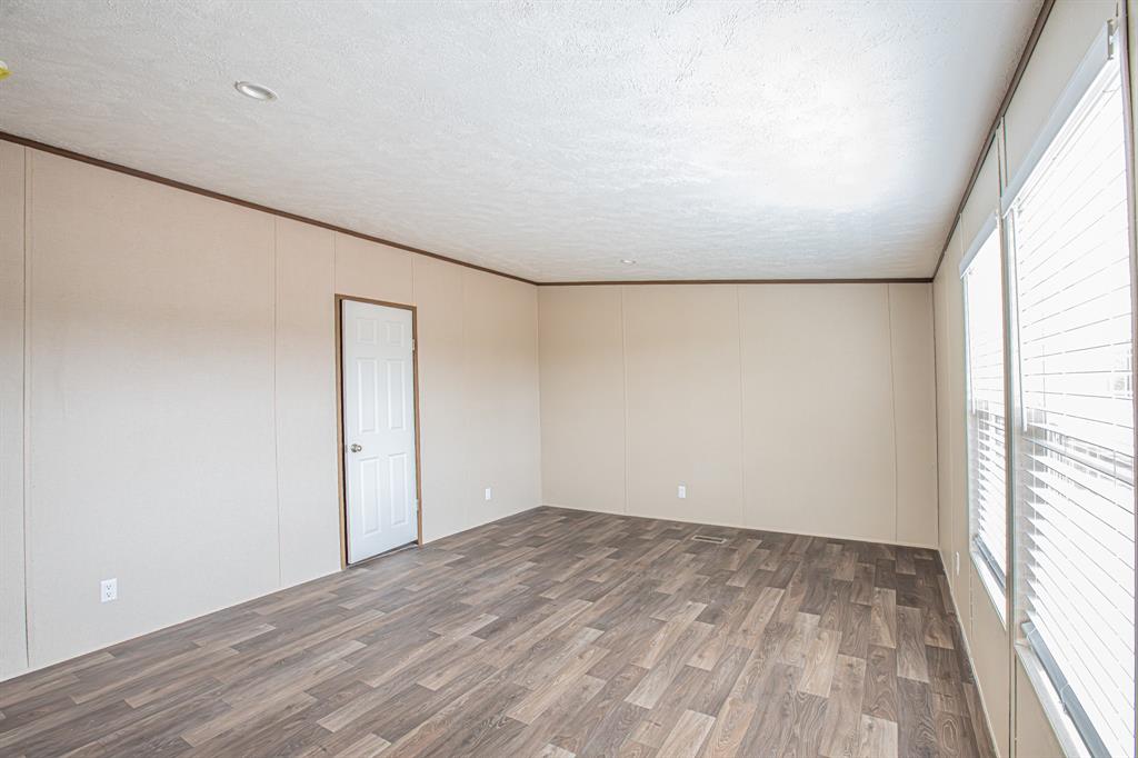 150 Leech Road Poolville, TX 76487 - Photo 15 of 34 a view of empty room with wooden floor and fan