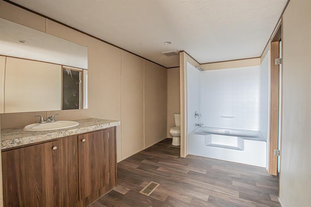 150 Leech Road Poolville, TX 76487 - Photo 19 of 34 a bathroom with a granite countertop sink and a mirror