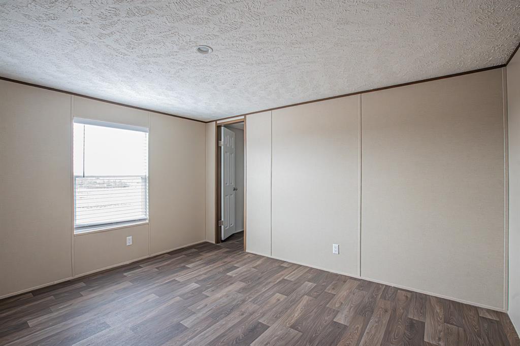 150 Leech Road Poolville, TX 76487 - Photo 26 of 34 an empty room with wooden floor and windows