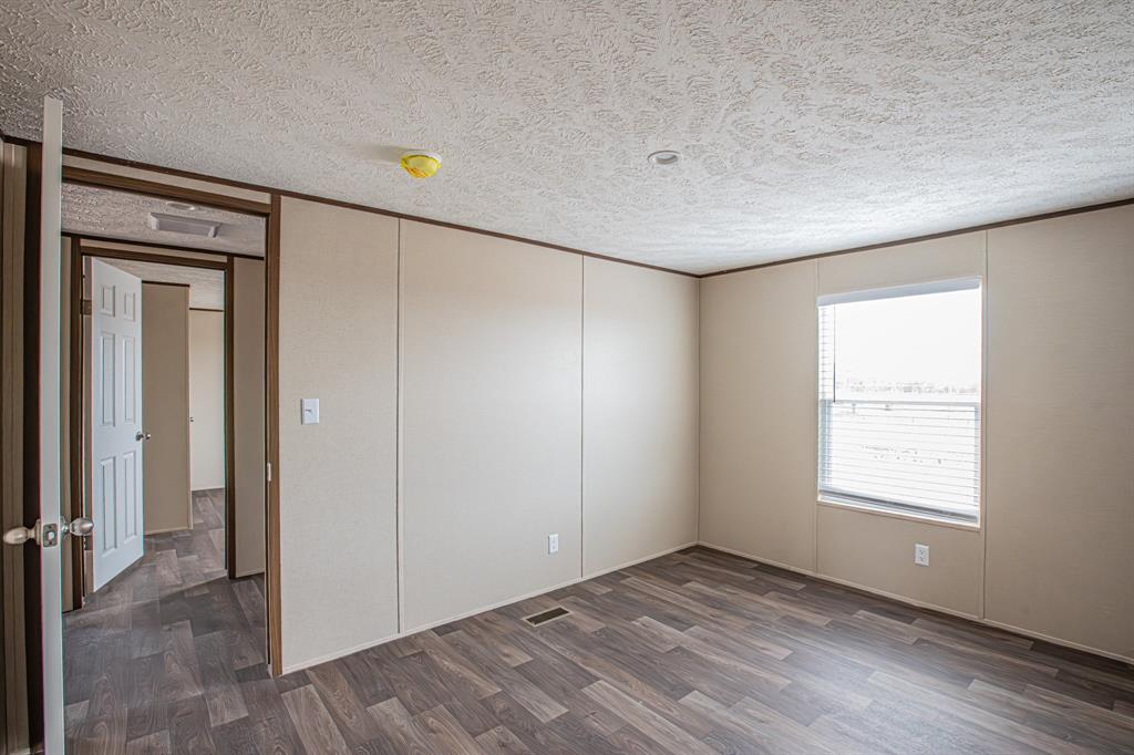 150 Leech Road Poolville, TX 76487 - Photo 29 of 34 a view of an empty room with wooden floor and a window