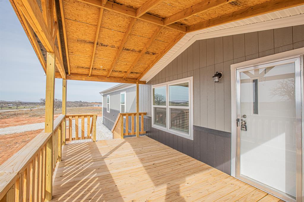 150 Leech Road Poolville, TX 76487 - Photo 4 of 34 a bedroom with a bed and wooden floor