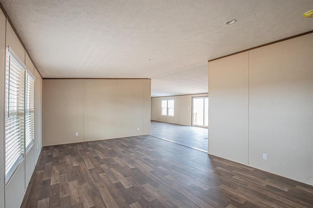 150 Leech Road Poolville, TX 76487 - Photo 6 of 34 a view of an empty room with wooden floor and a window
