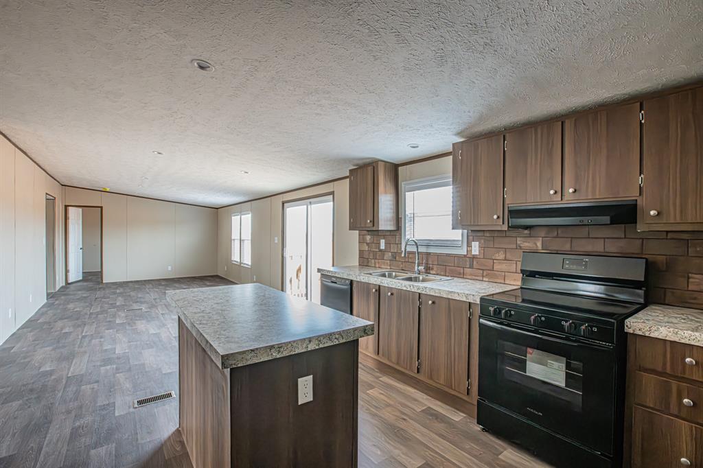 150 Leech Road Poolville, TX 76487 - Photo 9 of 34 a kitchen with stainless steel appliances granite countertop a stove a sink and a refrigerator