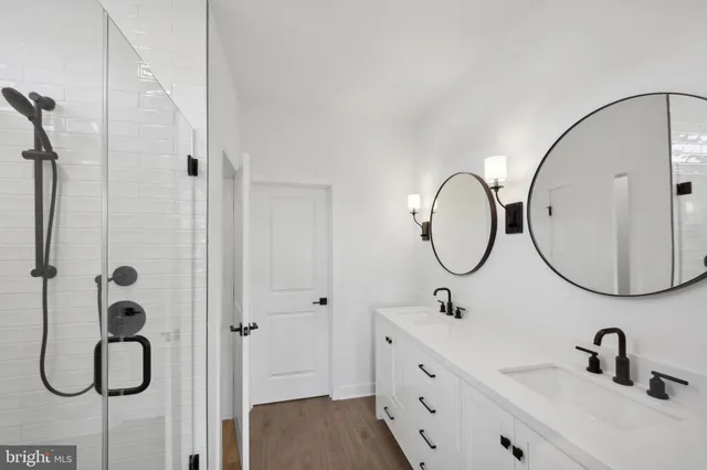 a bathroom with a double vanity sink mirror and shower